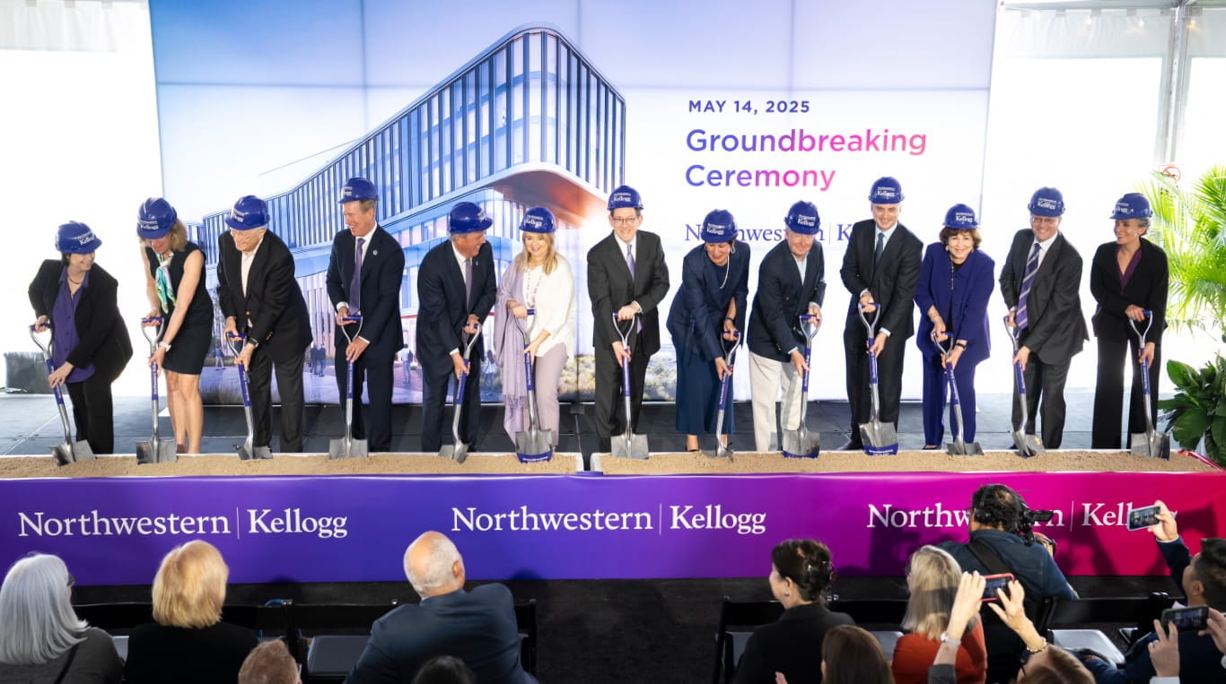 Kellogg supporters and university leaders wearing purple hard hats hold ceremonial shovels at the May 14, 2025 groundbreaking.