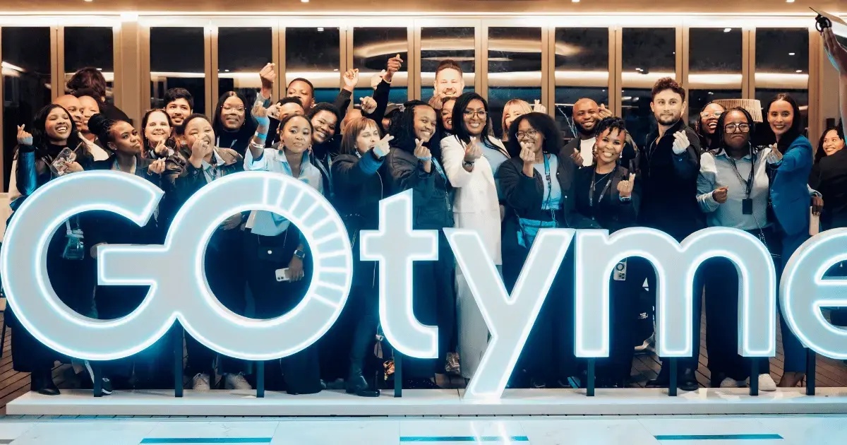 GoTyme team gathered behind illuminated bank lettering