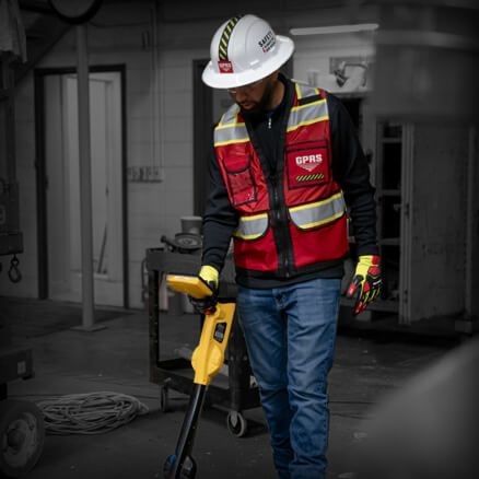 A GPRS field technician uses a yellow locating instrument inside a facility