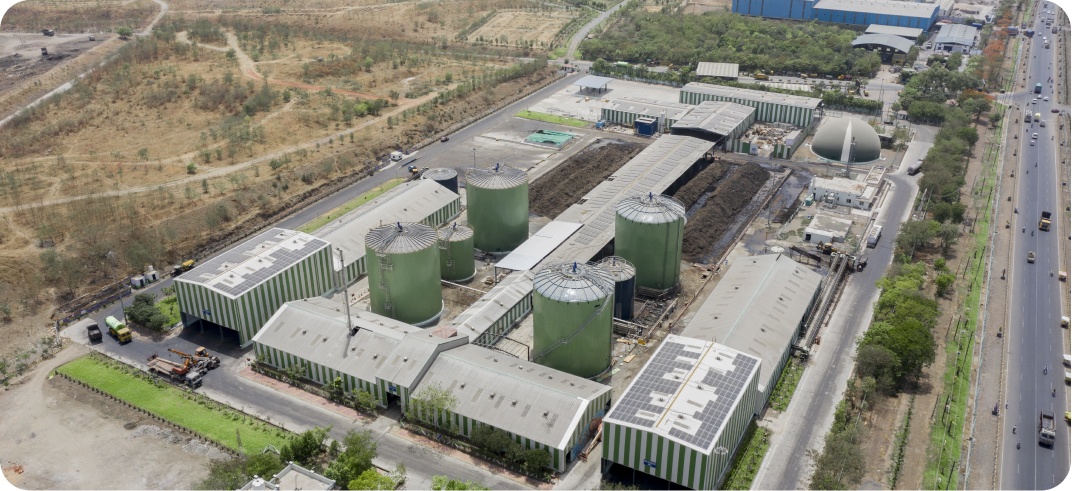 Aerial view of the Indore biogas facility, showing green digesters and processing buildings
