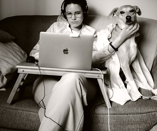 A recruiter working from a laptop beside a dog, from GR8 People's product imagery