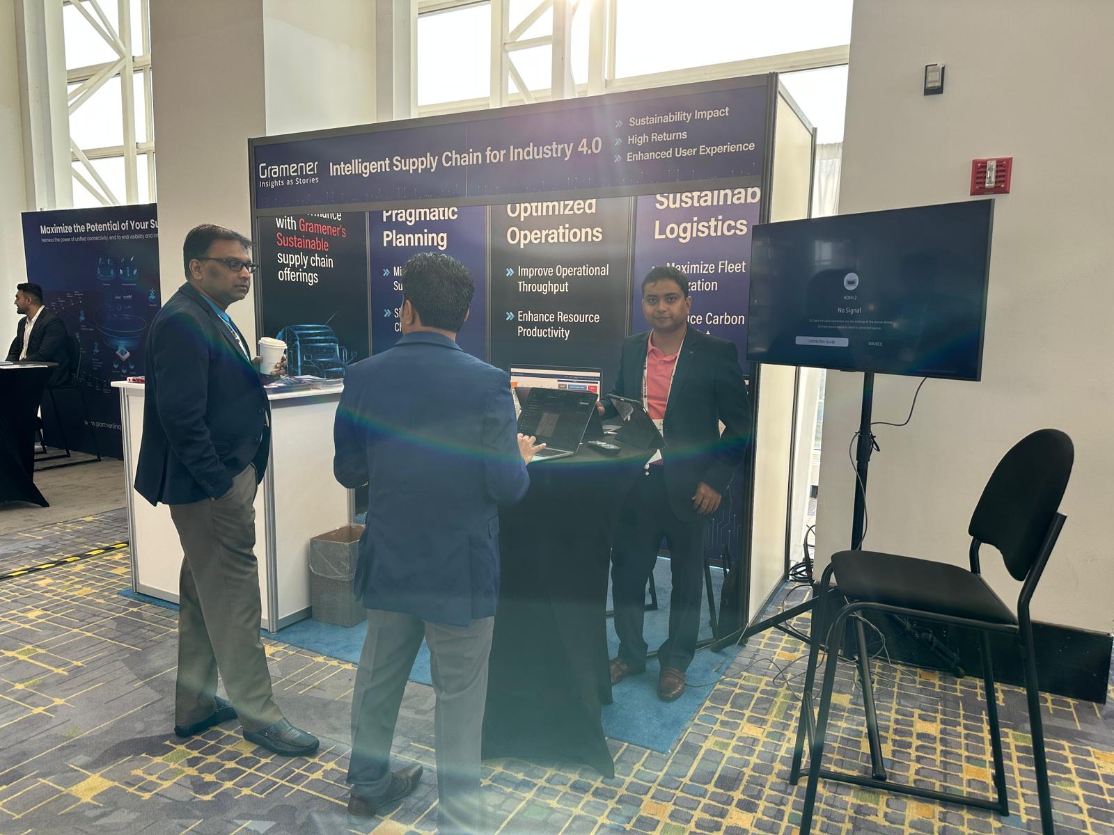 People discussing supply-chain applications at a Gramener exhibition stand