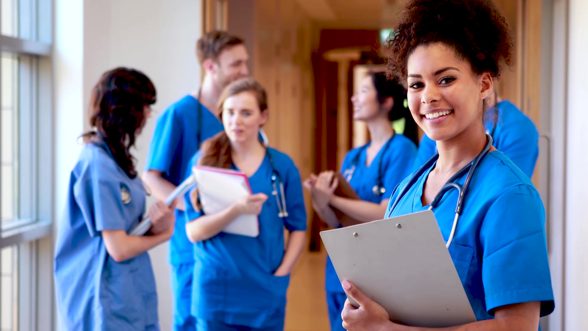 Nursing students in blue scrubs, pictured in Orbis Education’s promotional photography