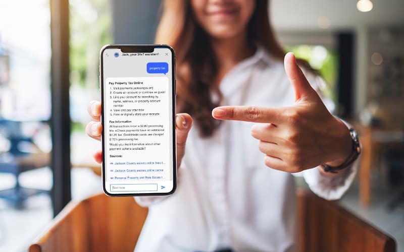 A person holding a phone that displays an AI answer about paying property tax online