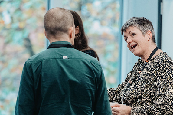 Three Granicus colleagues talking during a company gathering