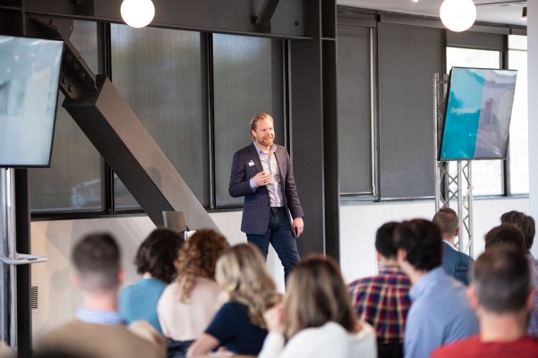 Grant Morgan speaking to seated colleagues at the R-Zero team summit