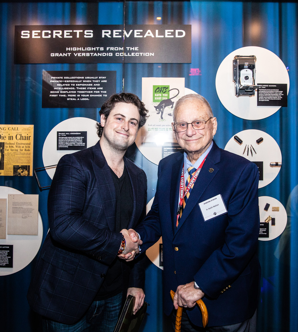 Grant Verstandig, left, shaking hands with H. Keith Melton in front of the Secrets Revealed exhibition