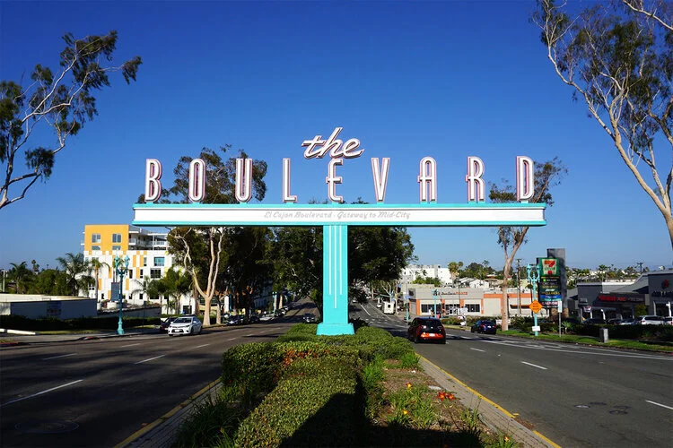 The Boulevard gateway, a turquoise median structure with tall lettering over El Cajon Boulevard