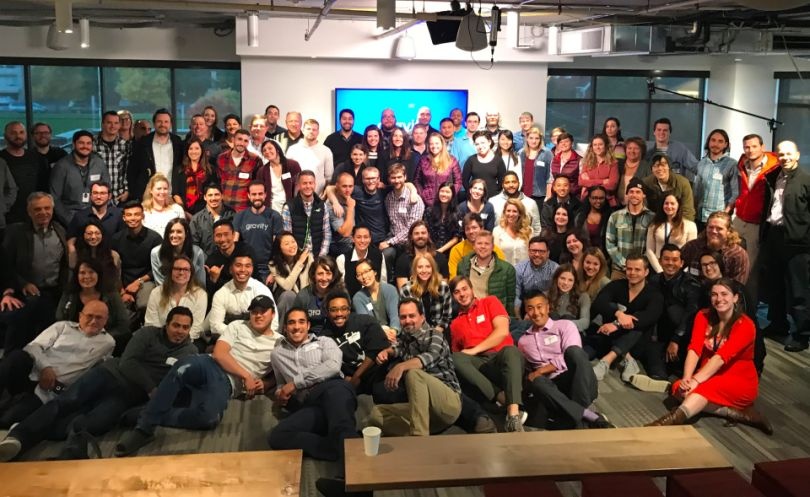 An archival group portrait of Gravity Payments employees gathered inside an office