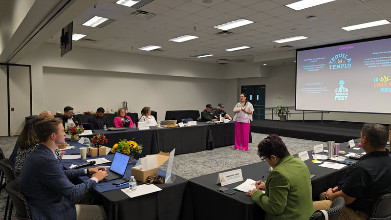 Participants seated around a U-shaped arrangement of tables during a ScaleUp presentation
