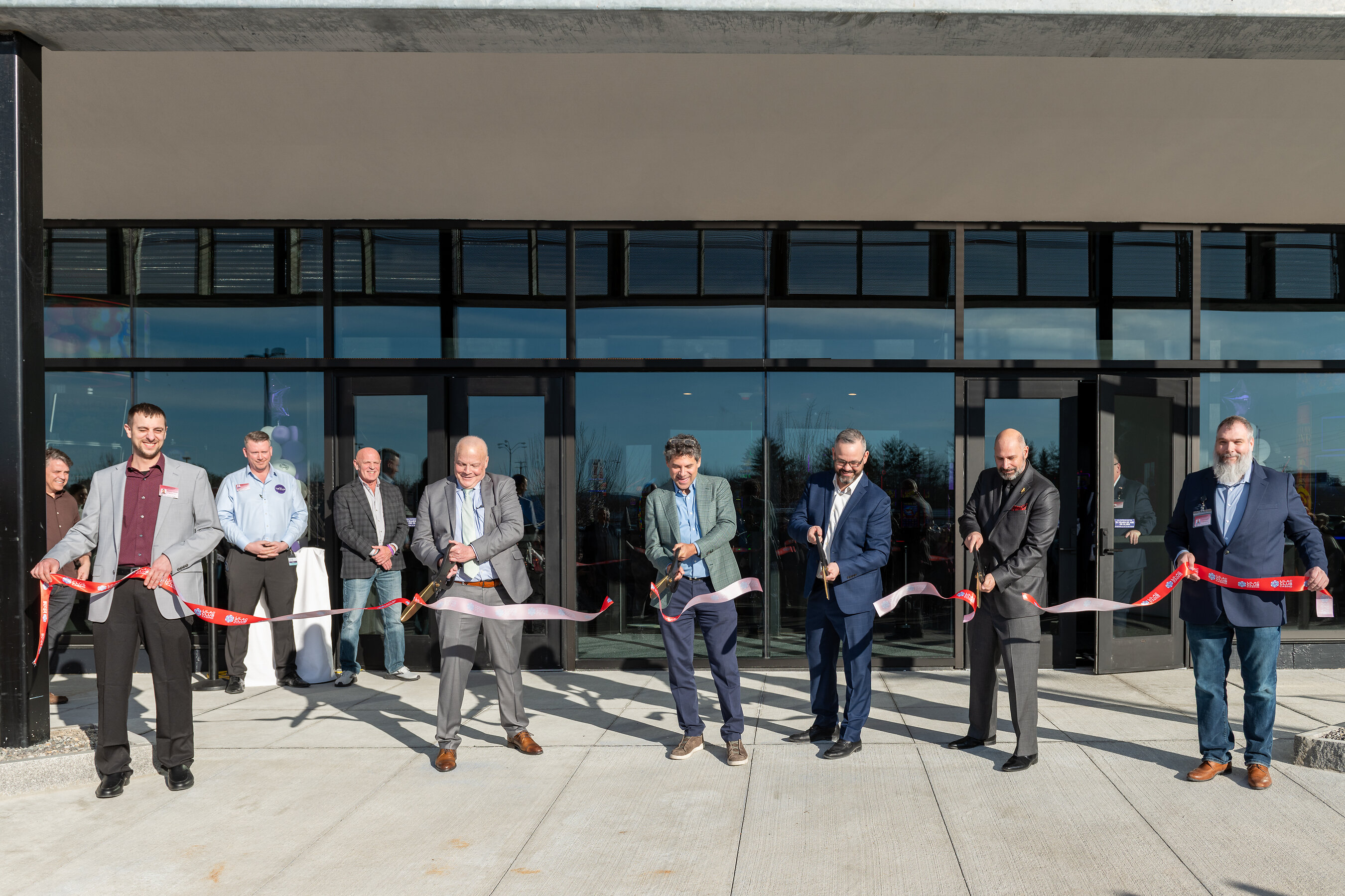 Greg Carlin, center in a green jacket, cuts the ribbon with casino and Rochester officials outside Lilac Club Casino.