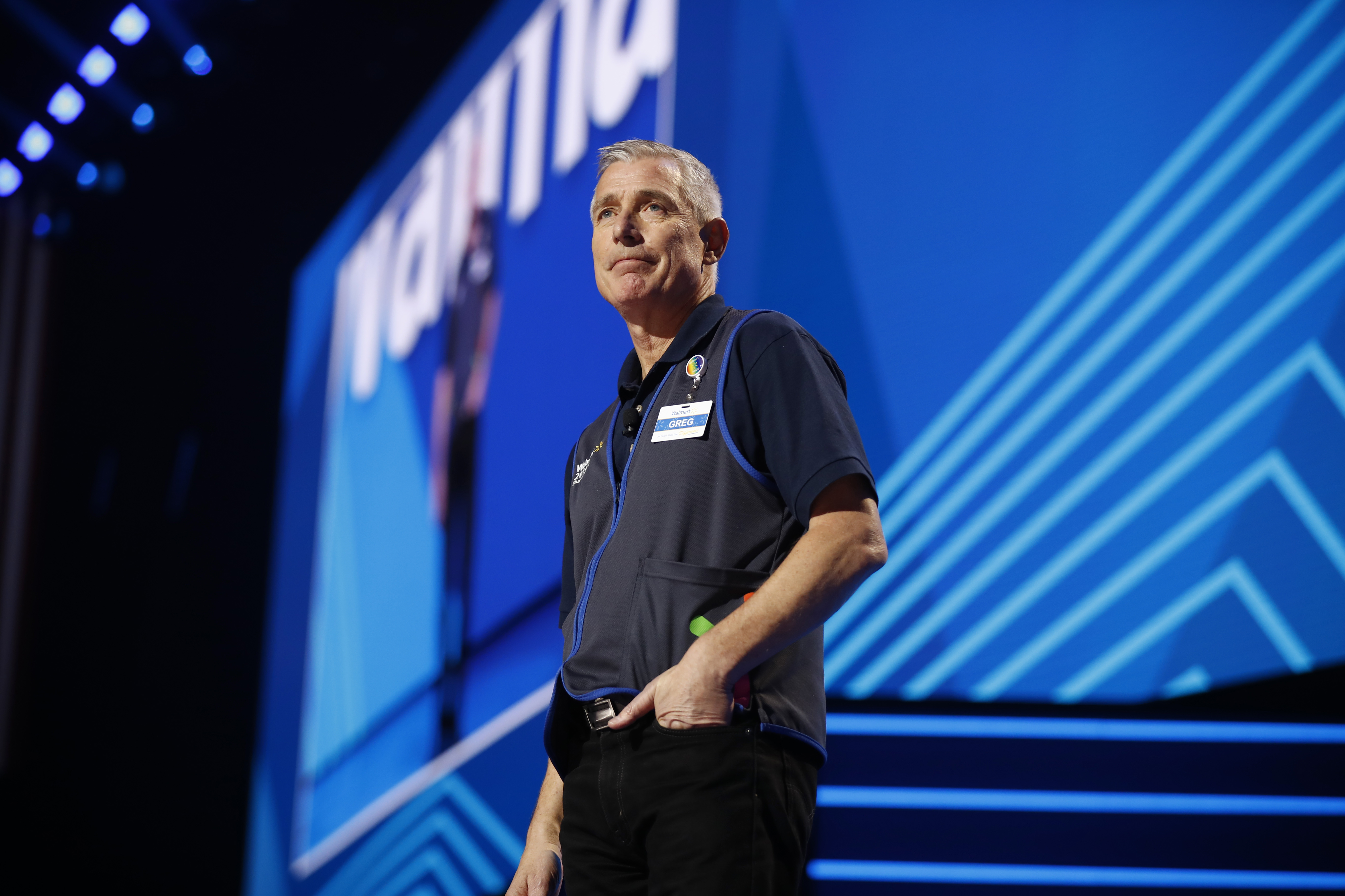 Greg Foran onstage in his Walmart vest at the 2019 associate and shareholders meeting