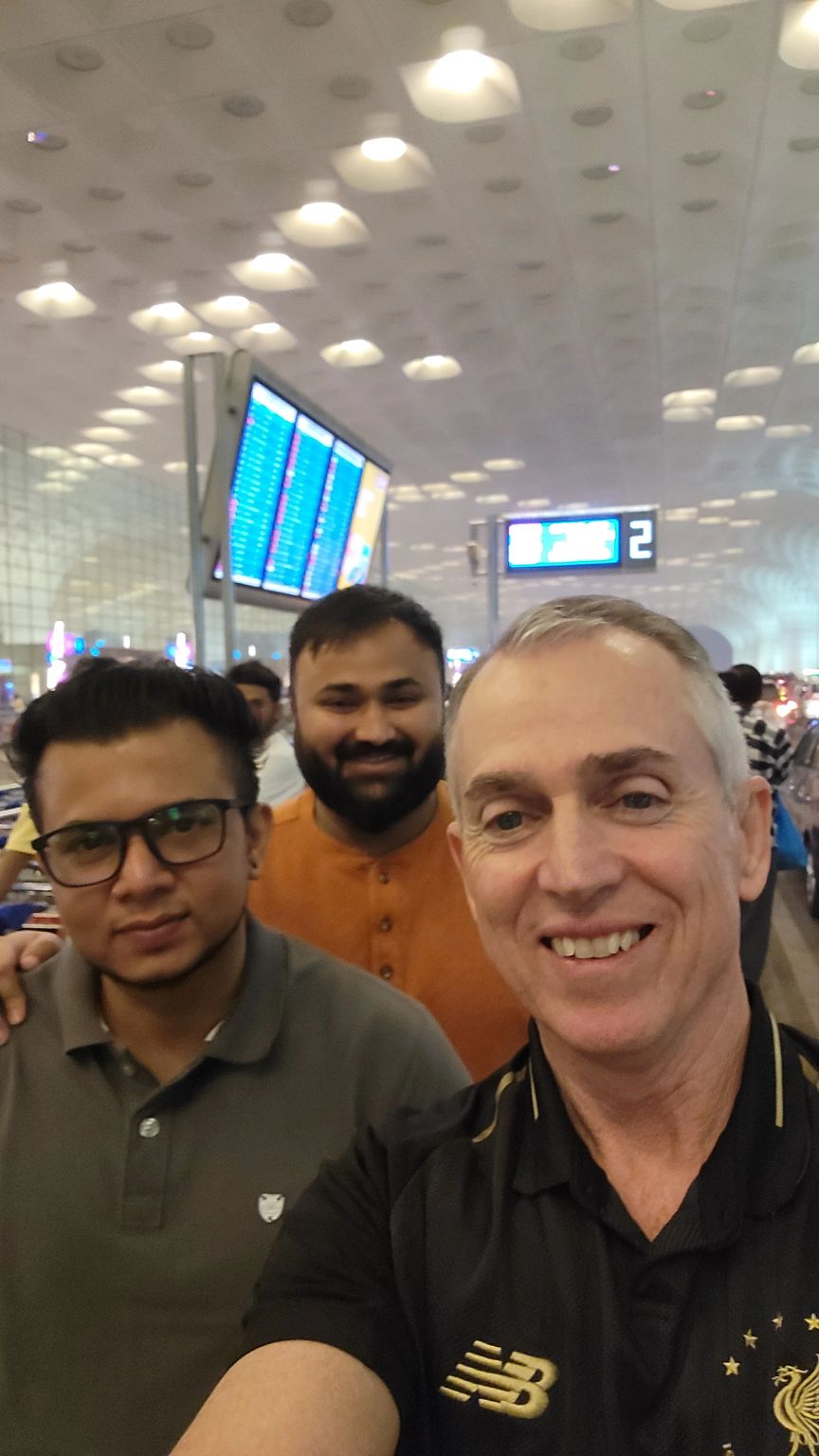 Greg Frick, right, wearing a Liverpool football shirt in an airport selfie with two companions