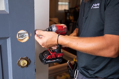 A KeyMe locksmith fitting hardware to a residential door