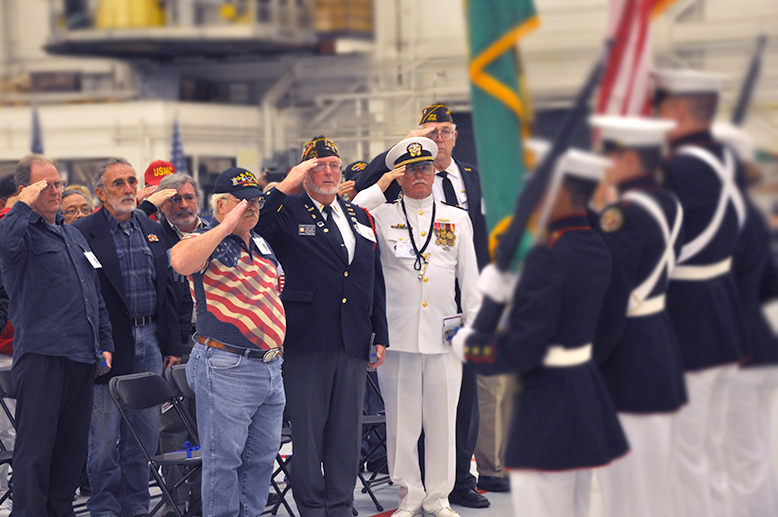 Veterans salute during an Alaska Air Group welcome-home ceremony in a Seattle hangar
