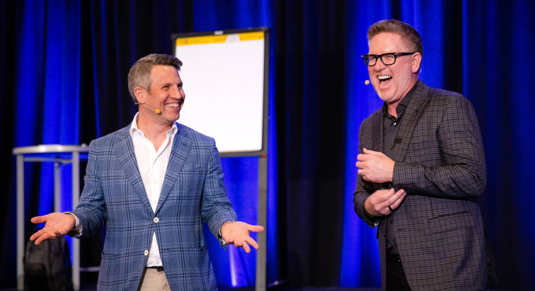 Greg Schwartz speaking onstage with Tom Ferry during a conversation about Tomo Mortgage