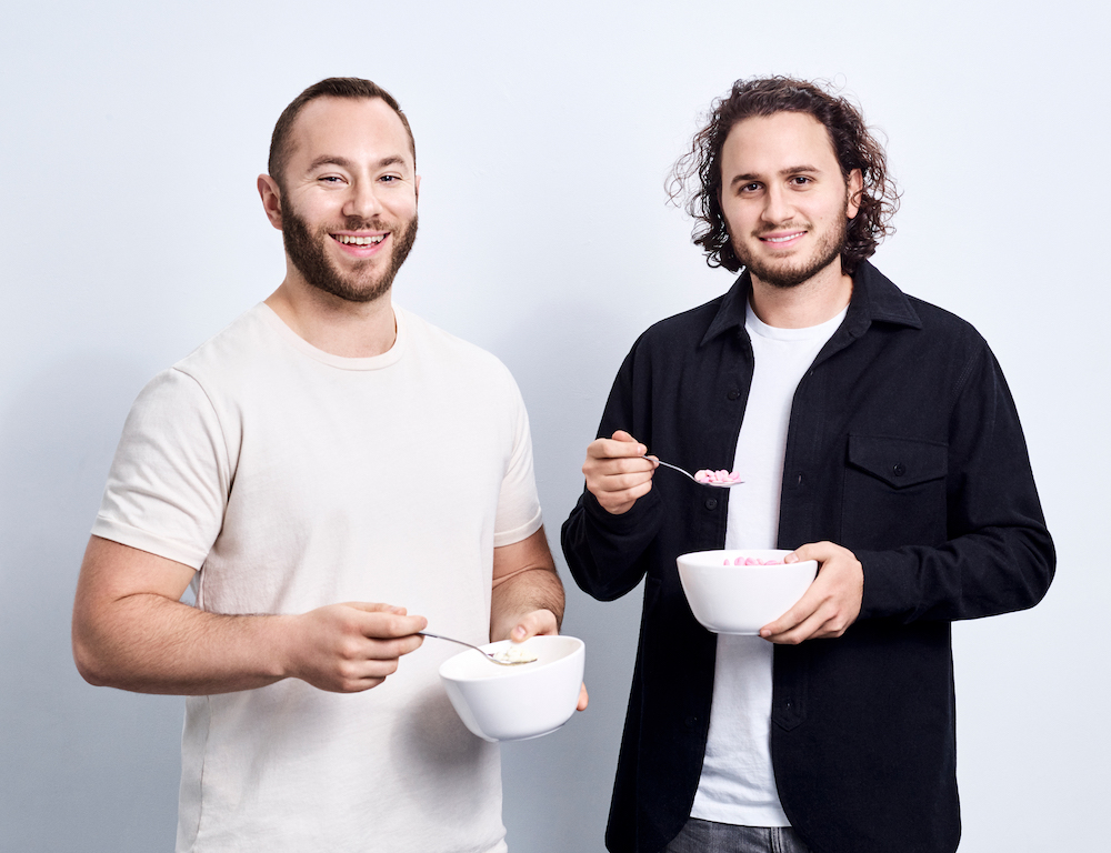Gabi Lewis, left, and Greg Sewitz, right, holding bowls and spoons of cereal
