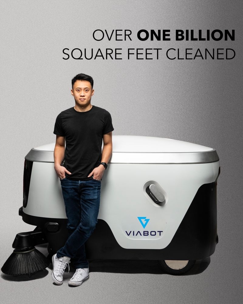 Gregg Ratanaphanyarat standing beside a Viabot sweeping robot