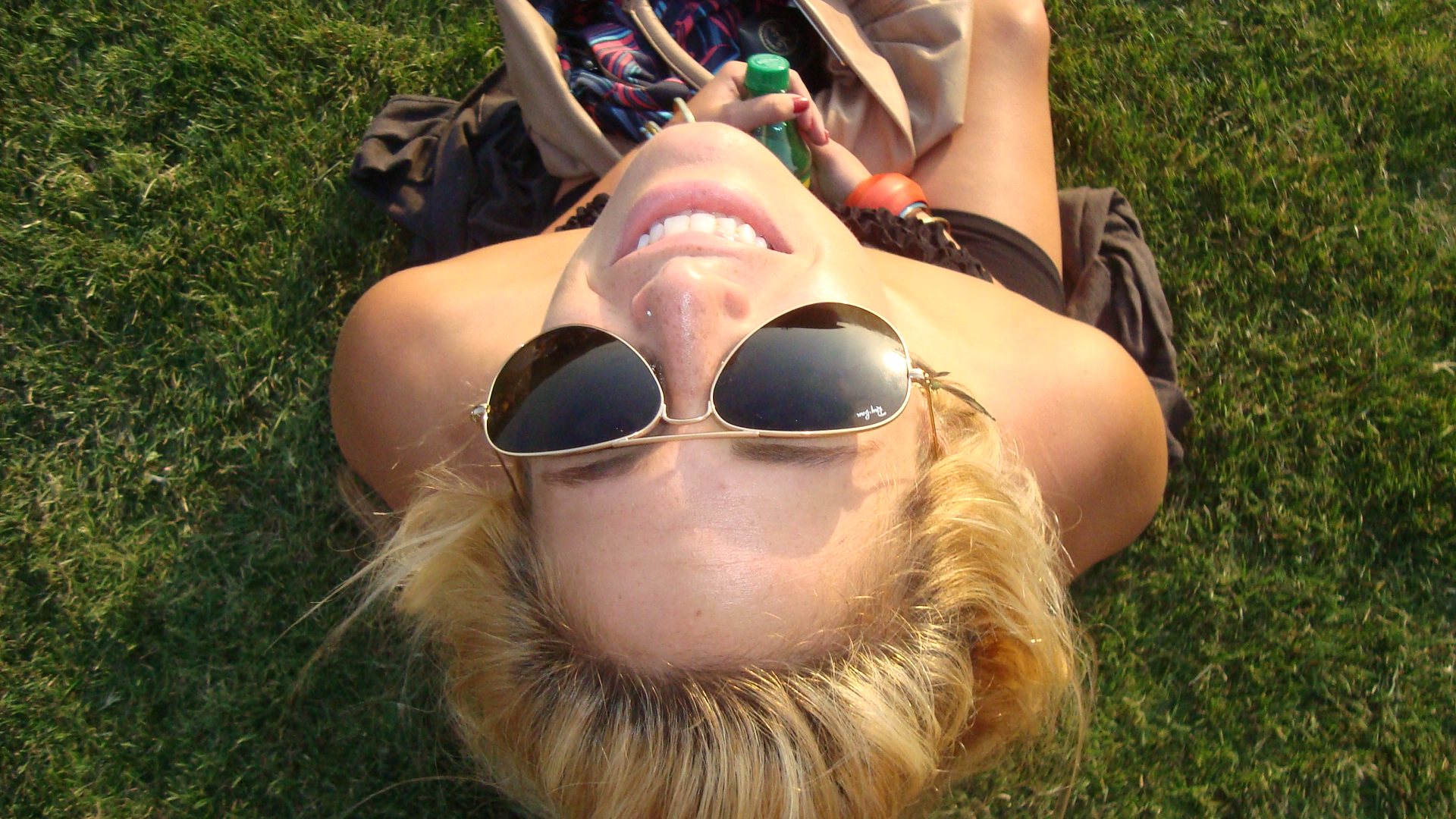 Greta Schmid reclining on the grass in sunglasses