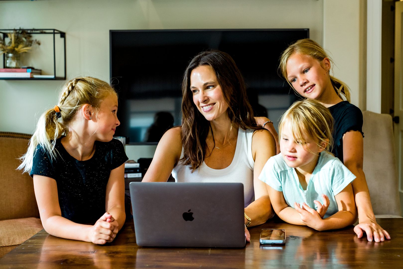 Gretchen Salyer at a laptop with her three daughters