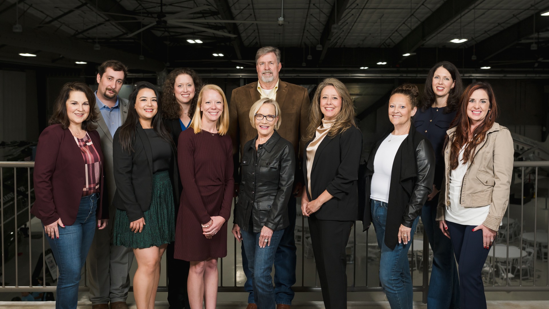 The Griffin Communications Group team standing together inside an aviation hangar