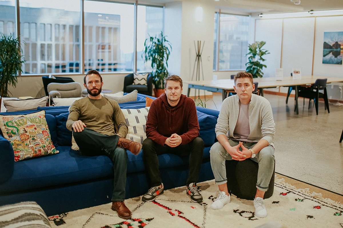 Three early GRIN leaders seated on a blue couch in an office