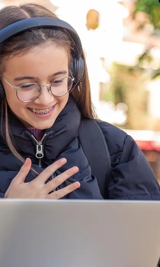 Student wearing headphones while using a laptop, from Growing Stars' website