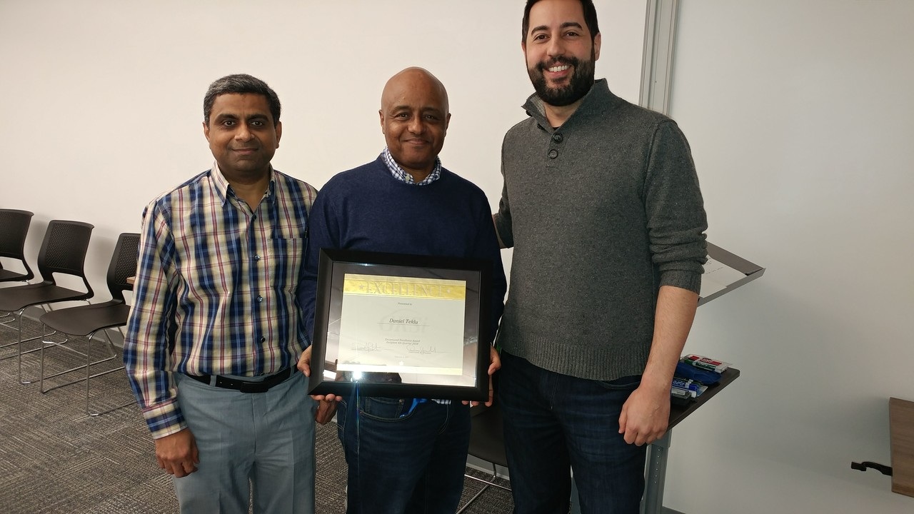 Raj Jagtap, award recipient Daniel Teklu and Brian Bookman at a GRSi staff recognition event