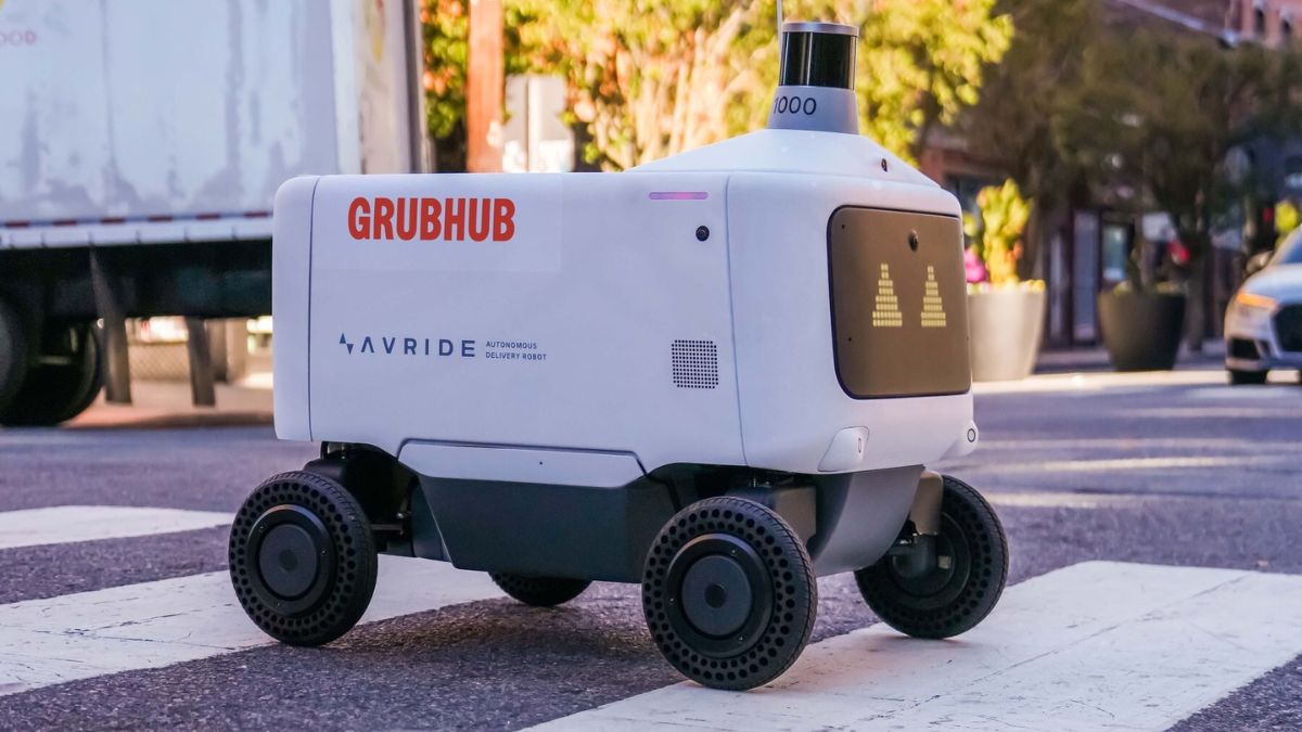 A four-wheeled Grubhub and Avride delivery robot at a city crosswalk