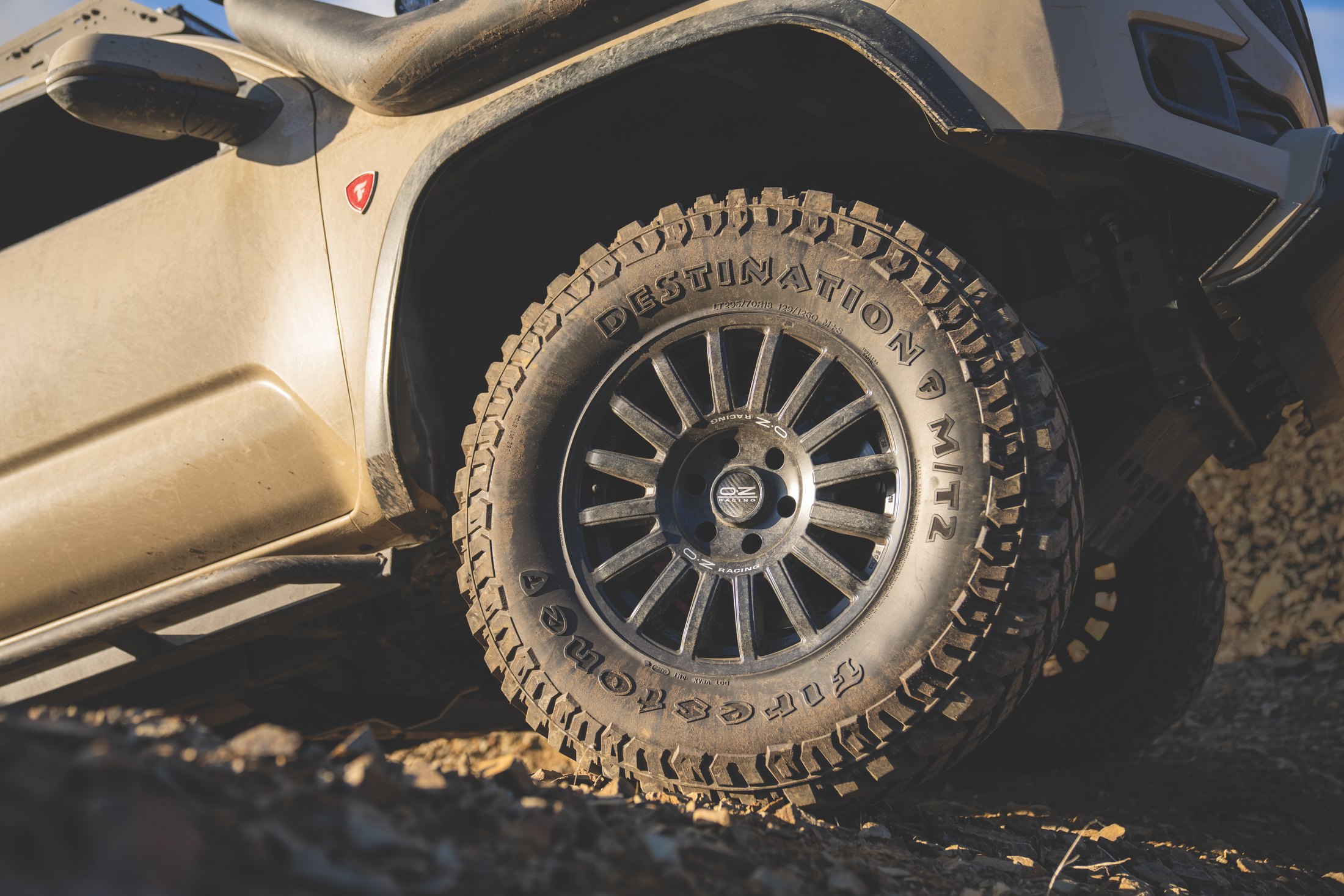 A Firestone Destination M/T2 tire on an off-road vehicle in rugged terrain
