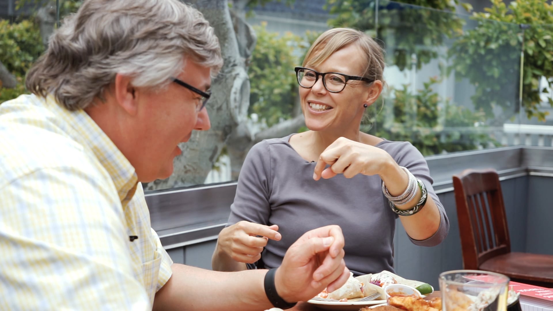 Guusje Bendeler talking with James McDonald over lunch in an outdoor restaurant