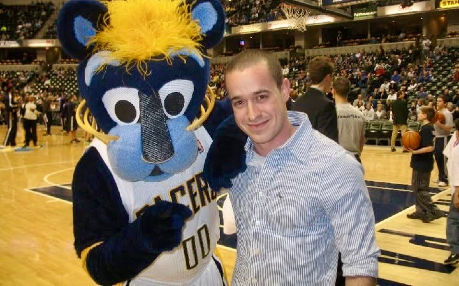 Guy Shahar beside the Indiana Pacers mascot at a basketball game