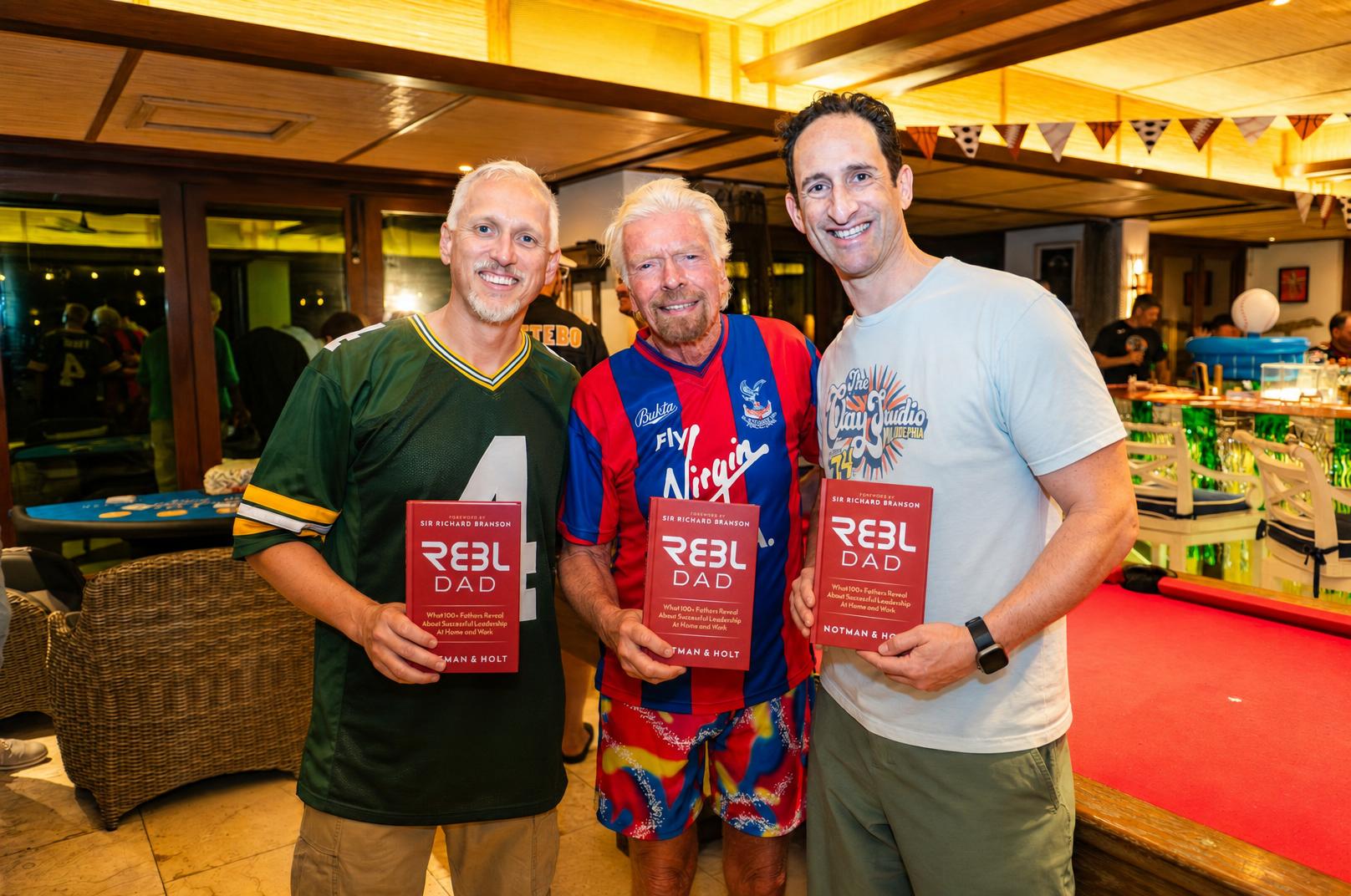 Derek Notman, Richard Branson and H. Adam Holt holding copies of REBL Dad