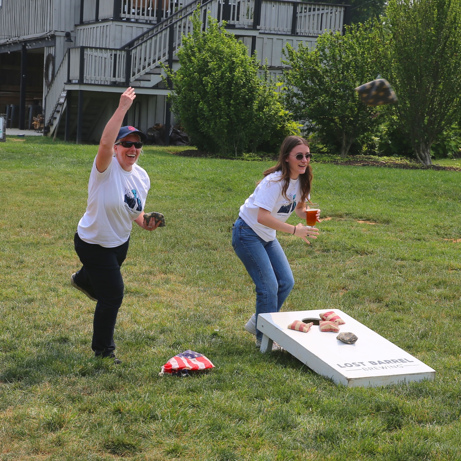 Two Hager Sharp team members playing cornhole outdoors
