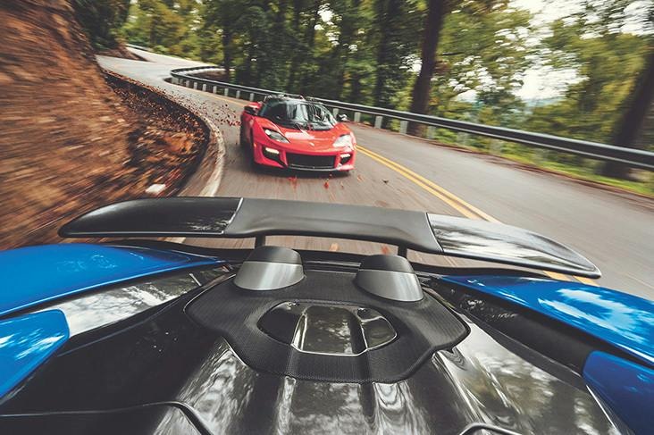 Two sports cars on a winding wooded road in Hagerty marketing imagery