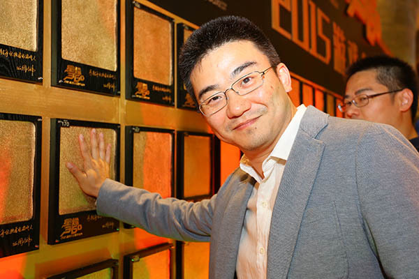 Haining Wang smiling beside his handprint at the 2015 Star Shine 360 event