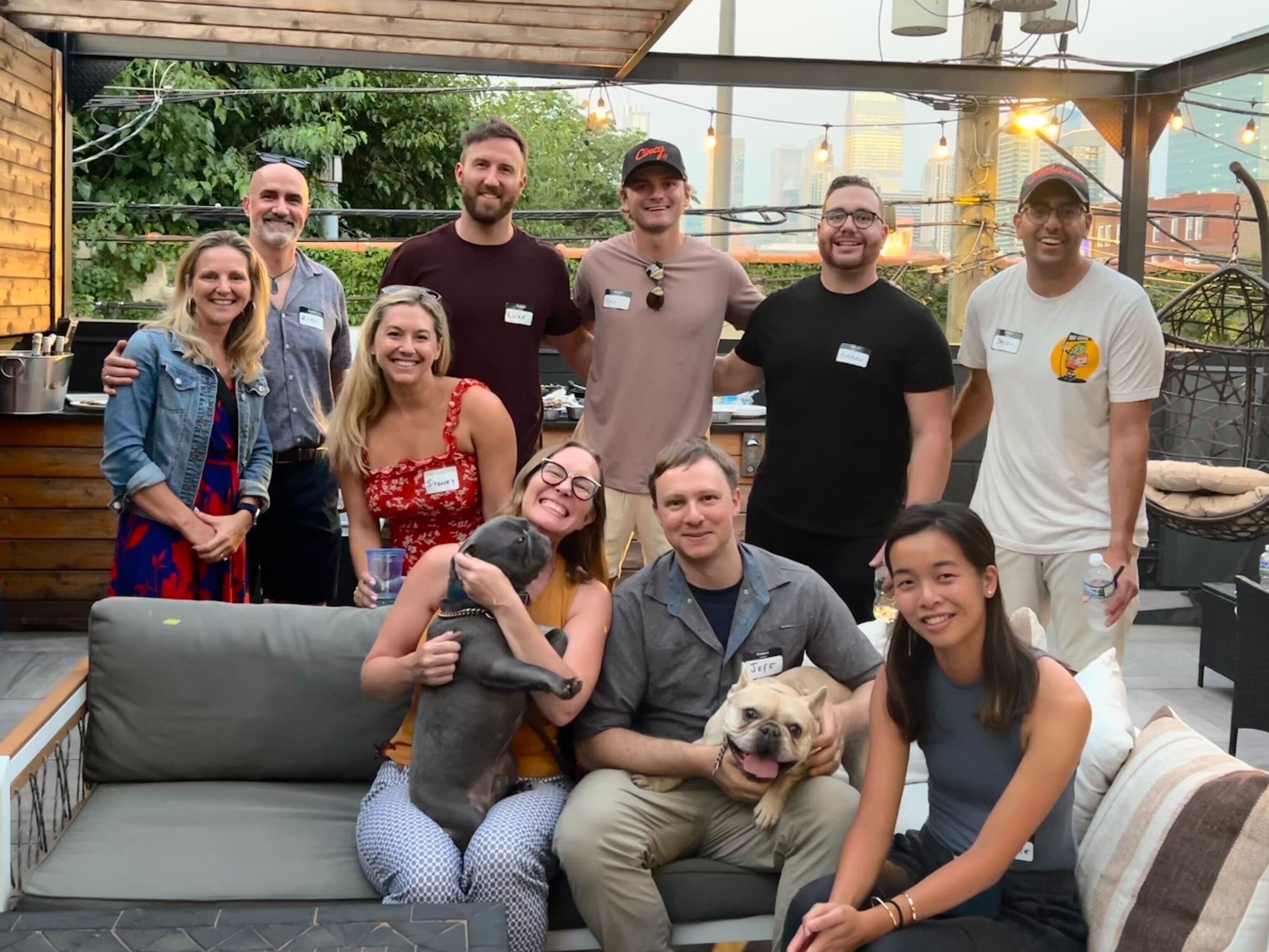 Hampton members gathered on a Chicago patio, with two dogs joining the group