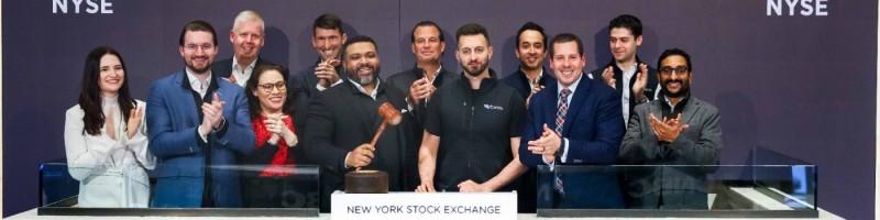 A group applauds around the bell podium at the New York Stock Exchange