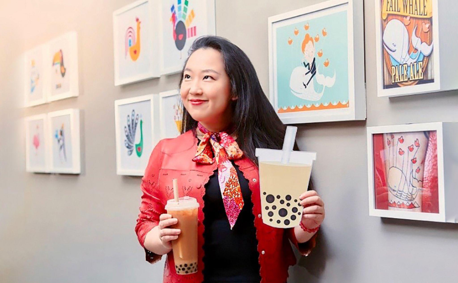 Yiying Lu standing with her colorful artwork