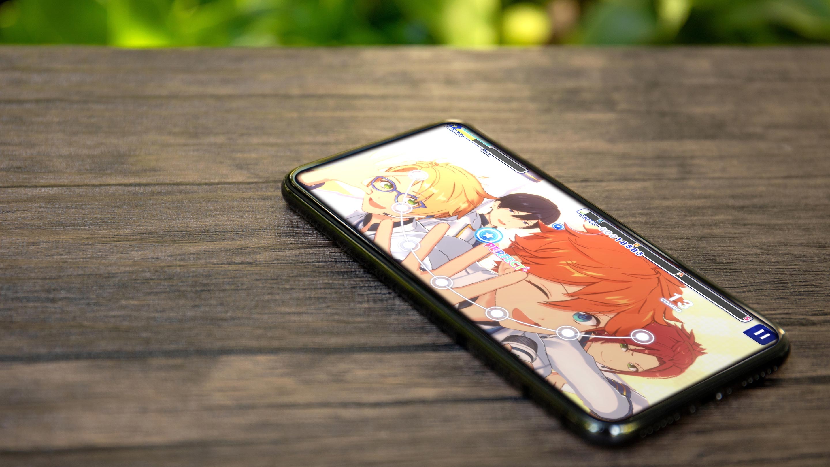 Ensemble Stars rhythm gameplay displayed on a smartphone resting on a wooden surface