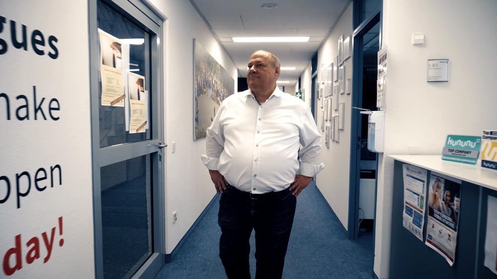 Harald Grumser standing in a Compart office corridor, hands on hips