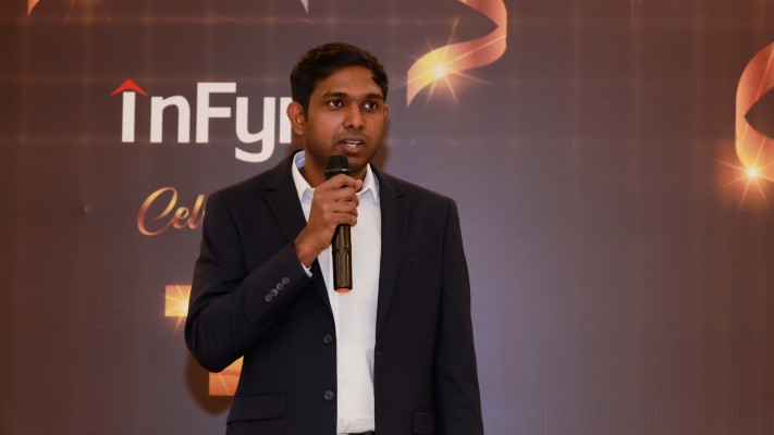 Harish Praveen holding a microphone at InFynd’s third-anniversary celebration