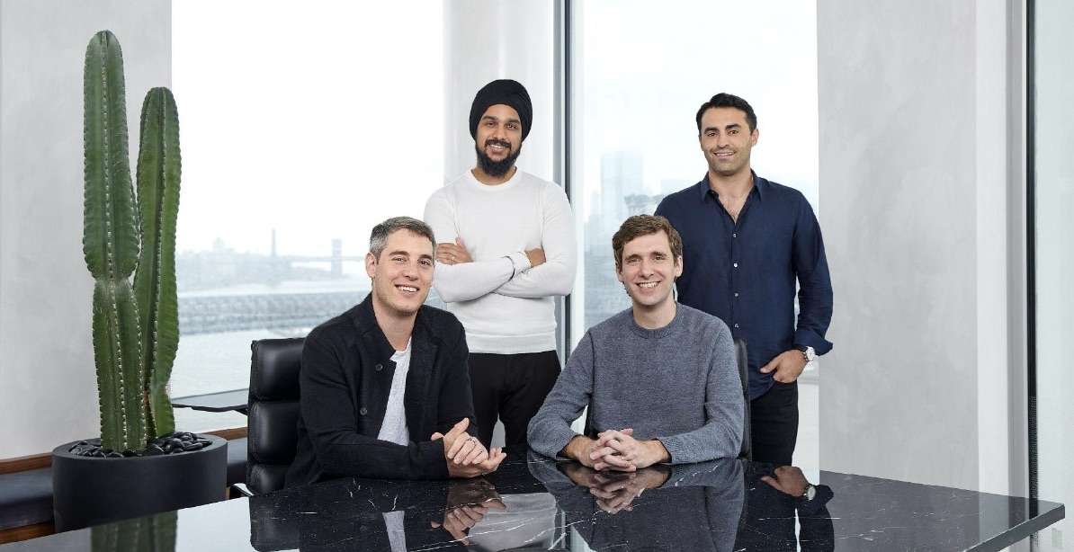 Four members of Left Lane Capital’s early leadership team gathered around a table in their office