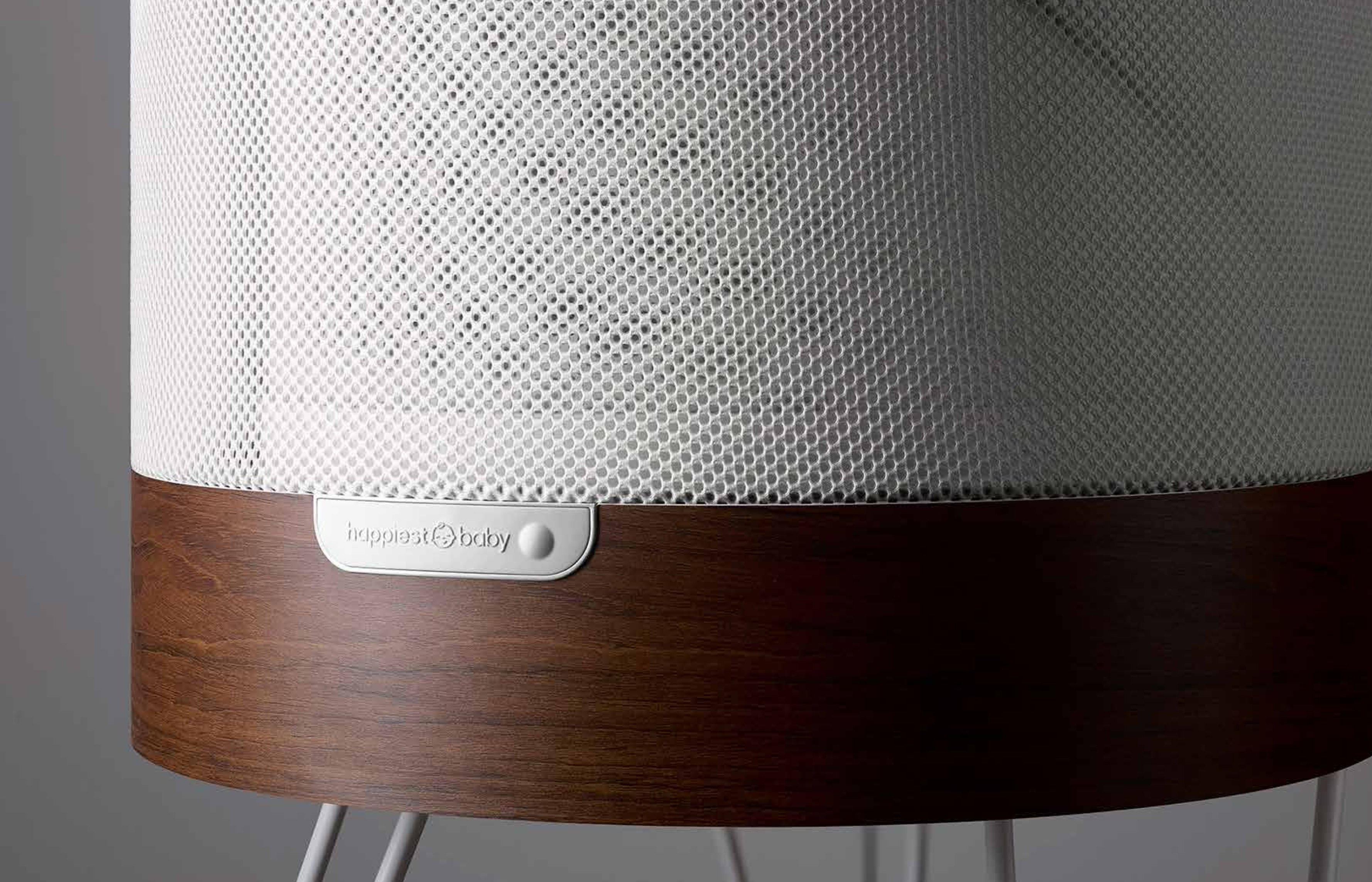 Close view of SNOO’s white mesh, wood base, and single button