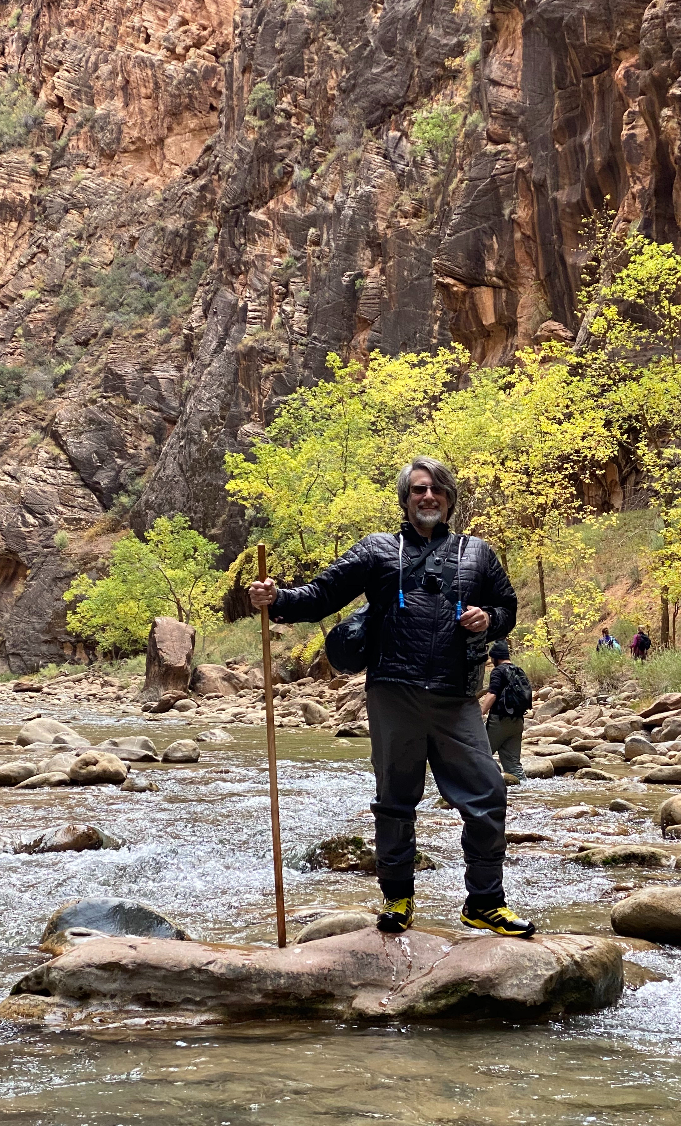 Hassan Sawaf with a walking stick beside the river in the Narrows at Zion National Park
