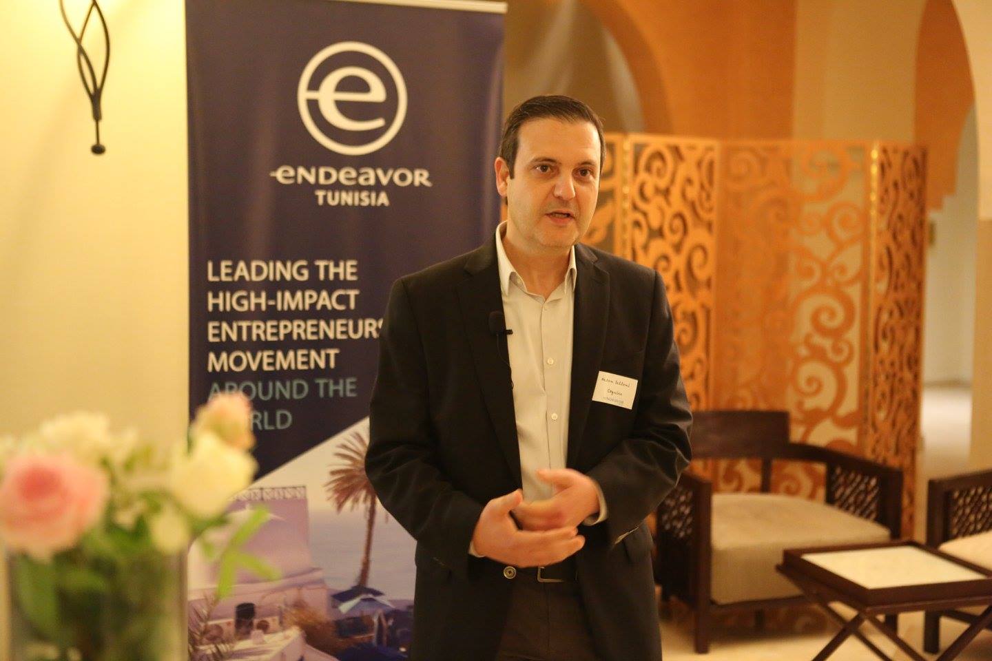 Hatem Sellami speaking beside an Endeavor Tunisia banner