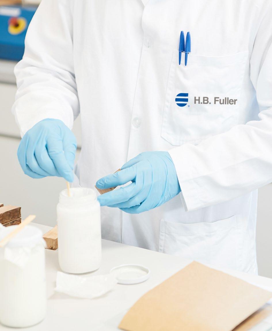 An H.B. Fuller laboratory worker in blue gloves preparing adhesive samples beside pieces of wood.