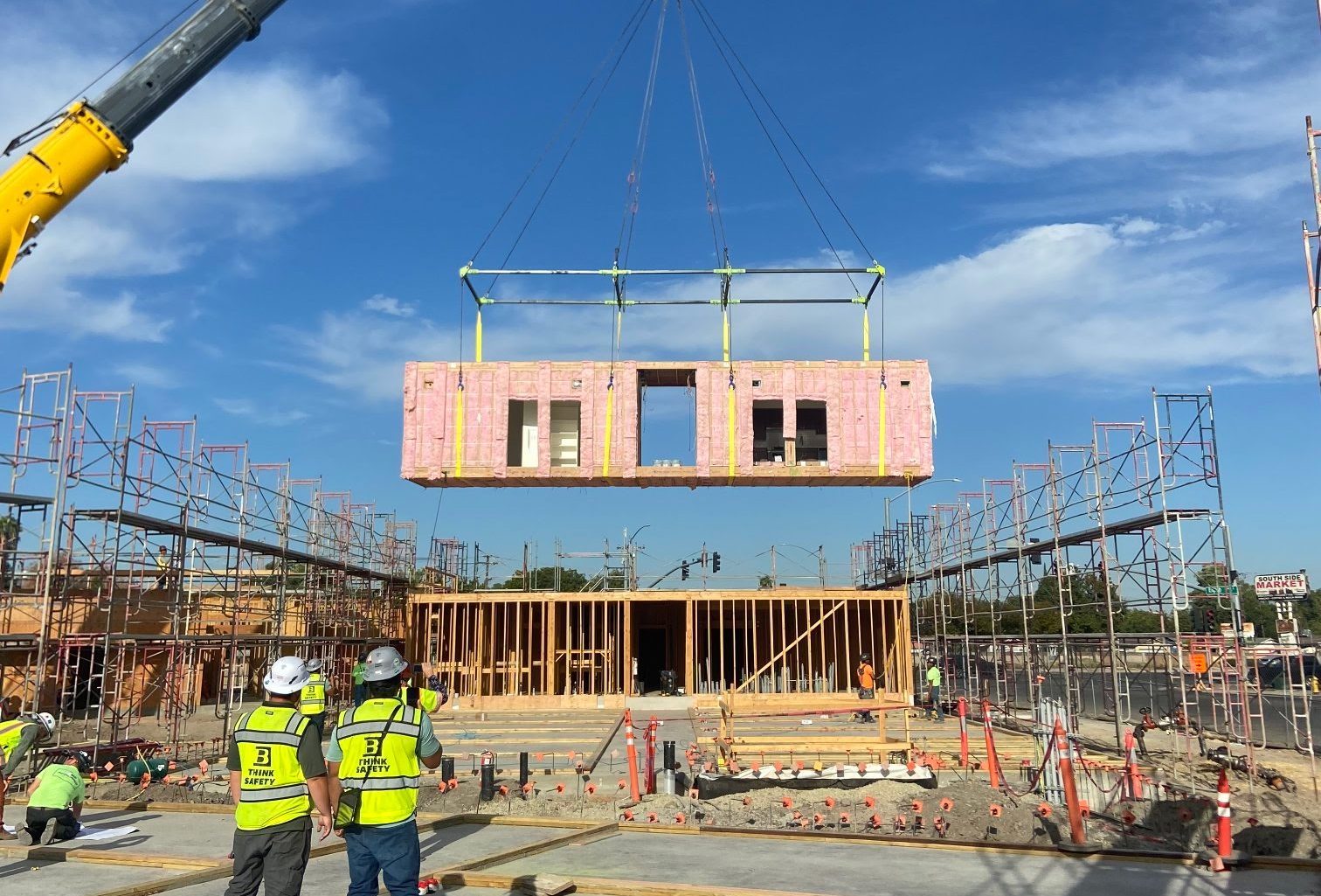 A crane lowers a modular housing unit into a building under construction at Fairview Terrace in Stockton