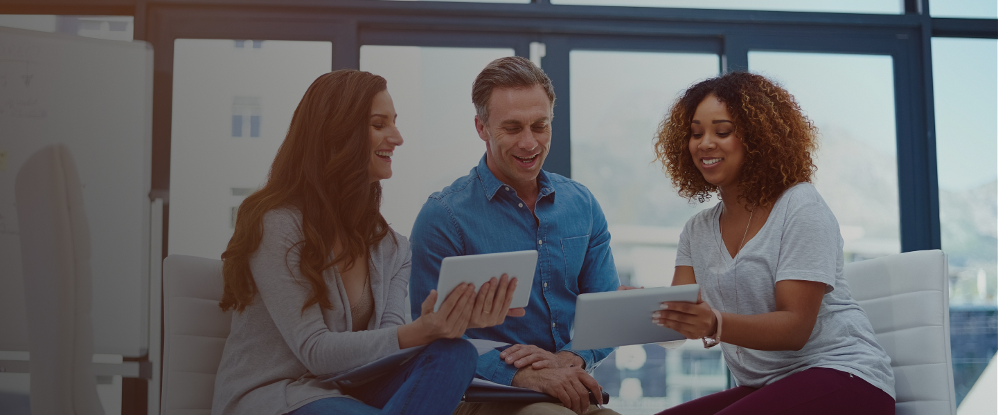 Healthcare technology professionals collaborating around a tablet