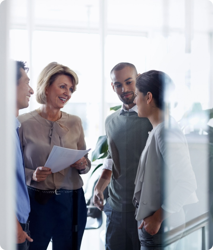 A group of colleagues in conversation in a bright office